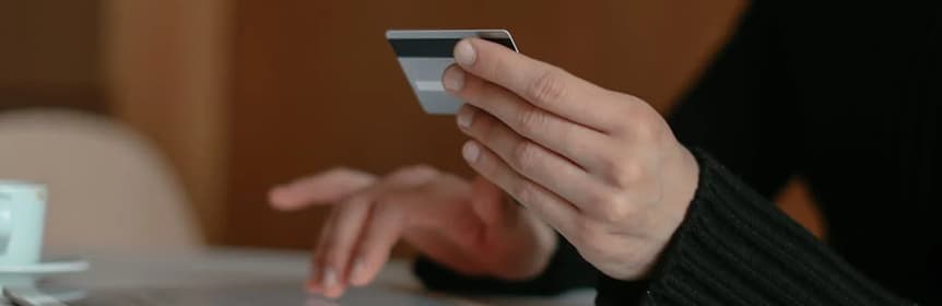 paiement_au_demarrage Someone paying with a credit card in front of a computer