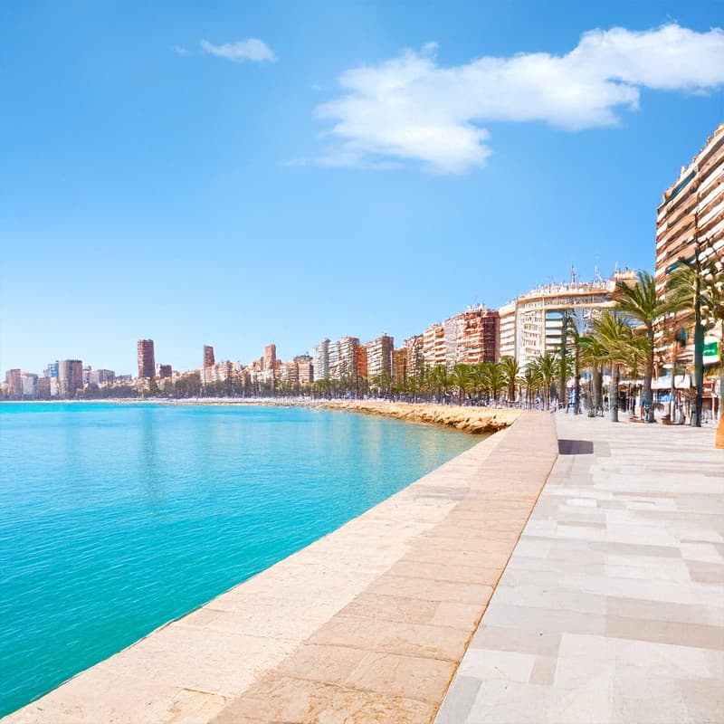 Turquoise waters along the Spanish coast with seaside apartments and vibrant promenade