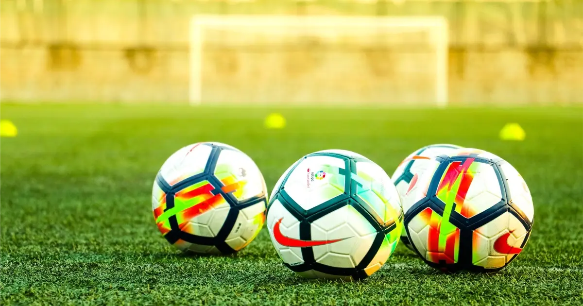 Soccer balls on a pitch in Spain, illustrating the strong football culture in the country