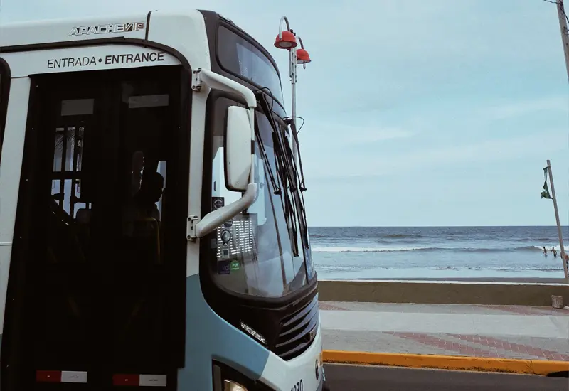 bus-spain-public-transport-cost-of-living Bus in Spain driving along the seaside, representing cost of living and public transport expenses