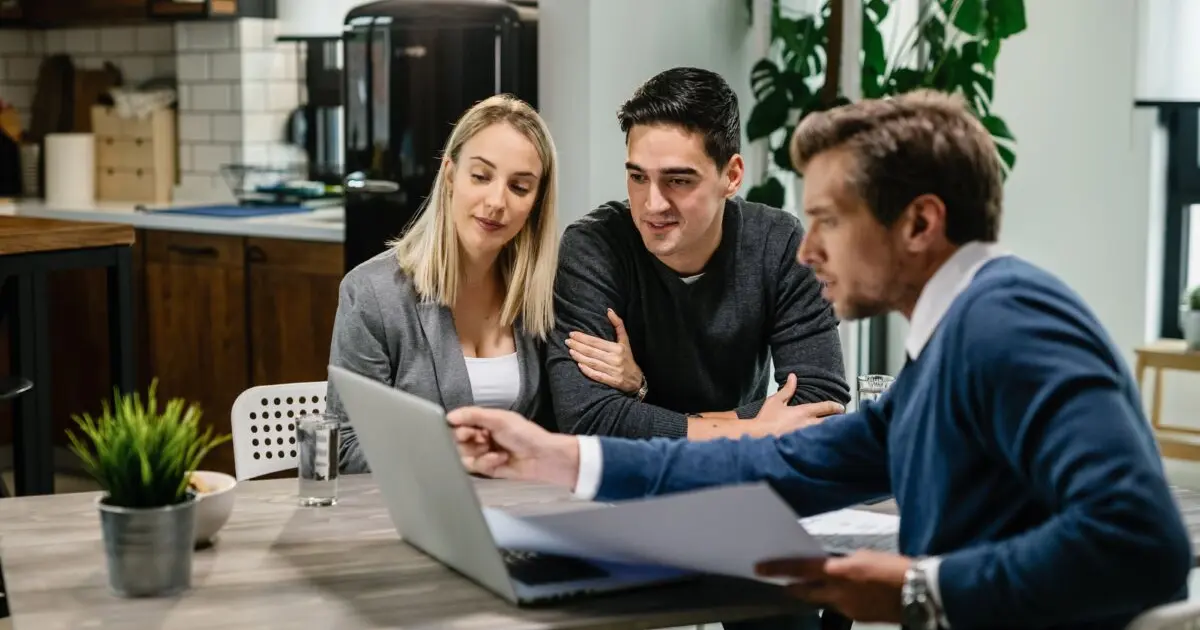 Couple meeting with a real estate professional, illustrating the difference between a real estate agent and a property hunter in Spain